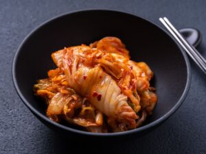 Freshly fermented Korean kimchi served in a black bowl, showcasing authentic flavors found at the Best Korean Restaurants.