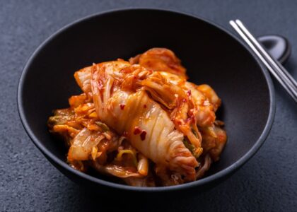 Freshly fermented Korean kimchi served in a black bowl, showcasing authentic flavors found at the Best Korean Restaurants.